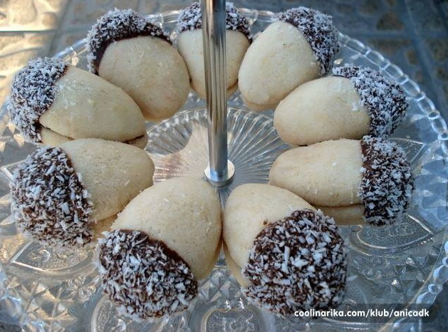 You are currently viewing Mali keksici -Zirovi-punjeni dzemom od kajsija ili sipka,umoceni do pola u finu,sjajnu glazuru od cokolade,pa uvaljani u kokos..
